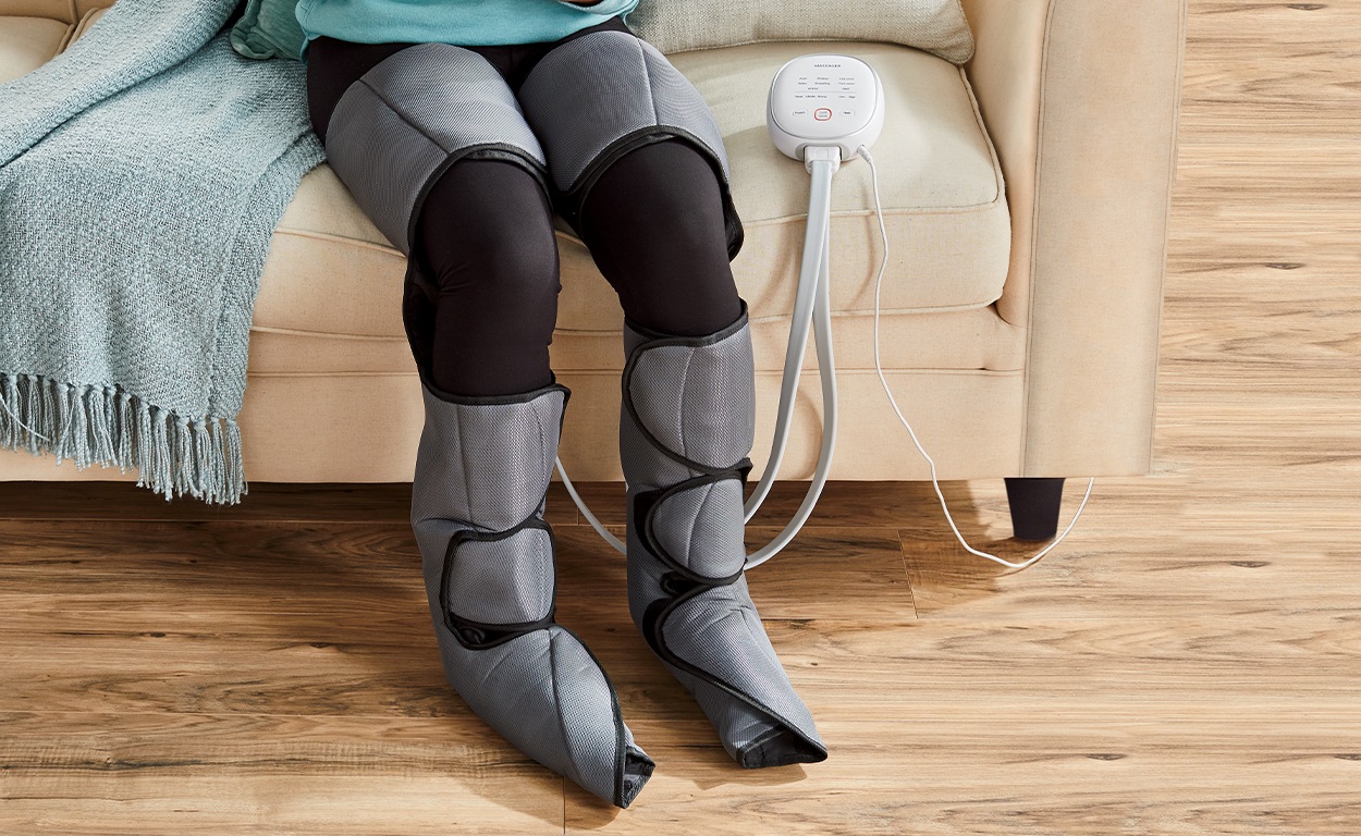 Heated Dual Leg Massager shown in use in a home setting on a woman's legs.